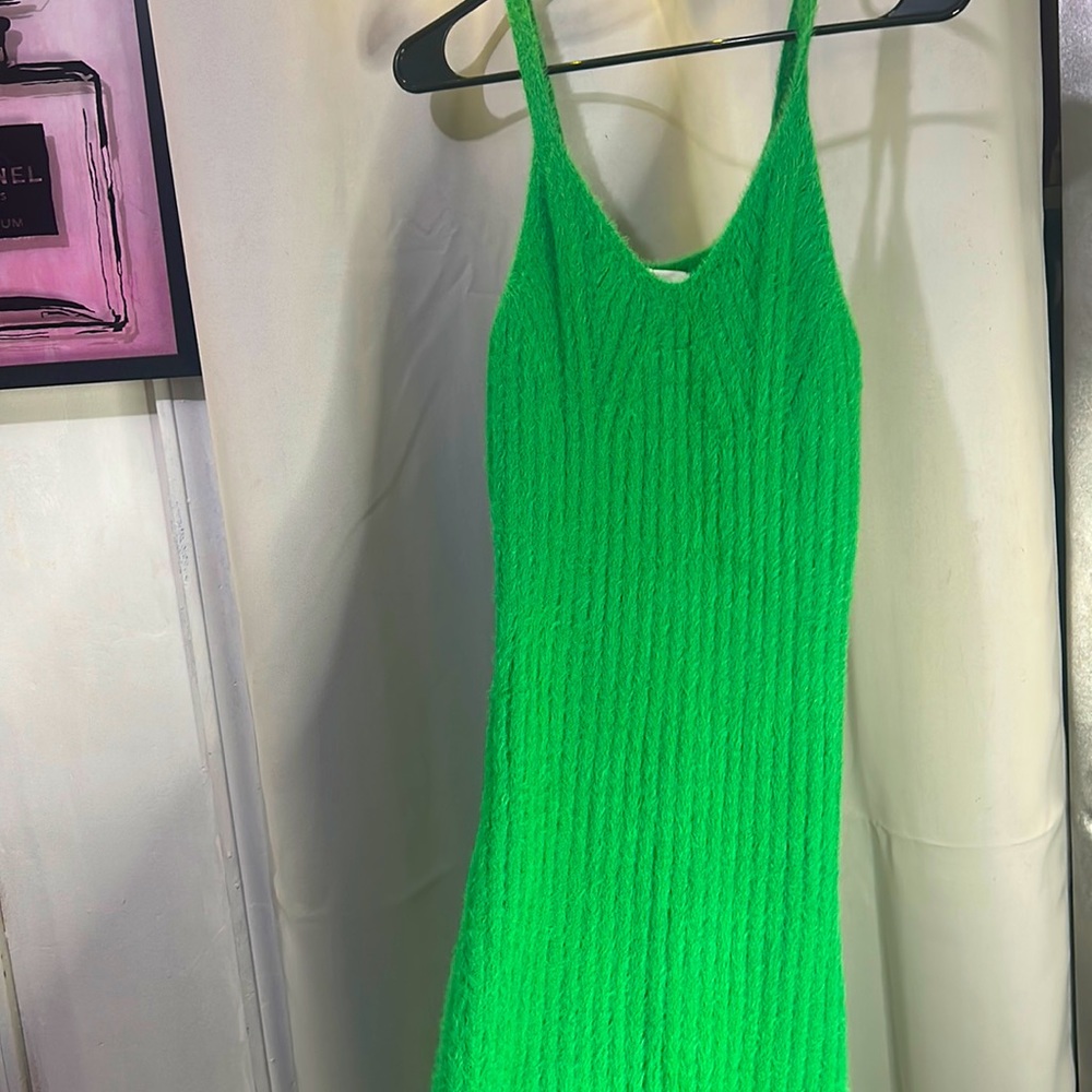 Mid length, green sleeveless dress, and unworn stretches out when on.